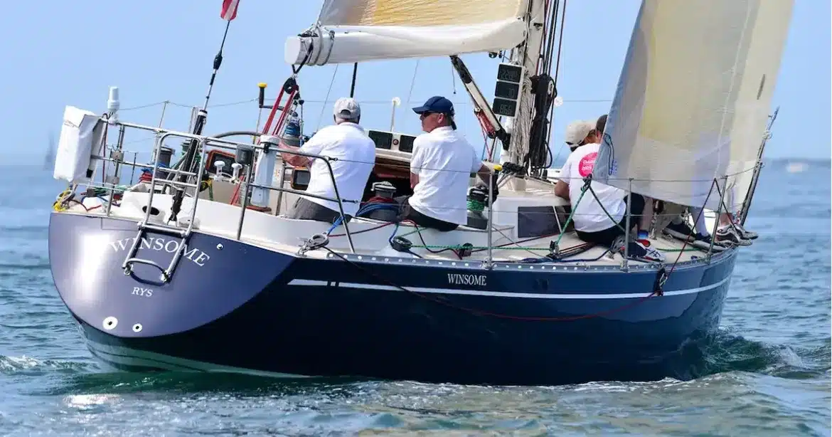 Classic yacht Winsome sailing under tan sails with a dark blue hull