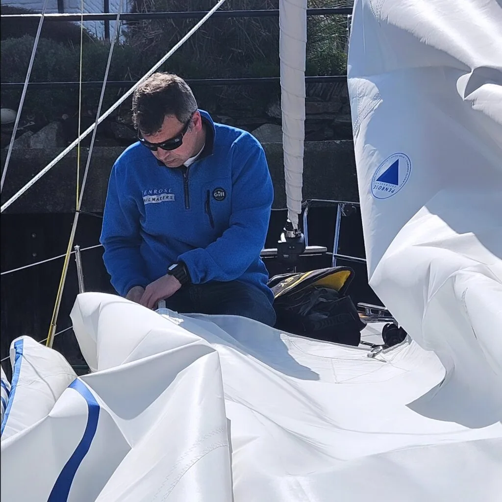 UK Sailmakers GBR South West staff member working on a flaked mainsail