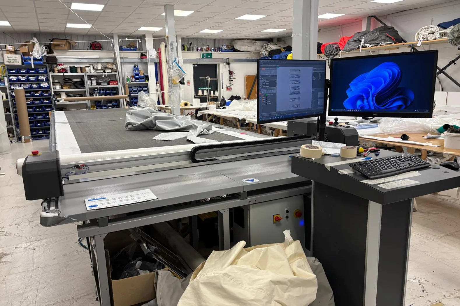 Sail design plotter and cutting table with computer monitors inside a sail loft