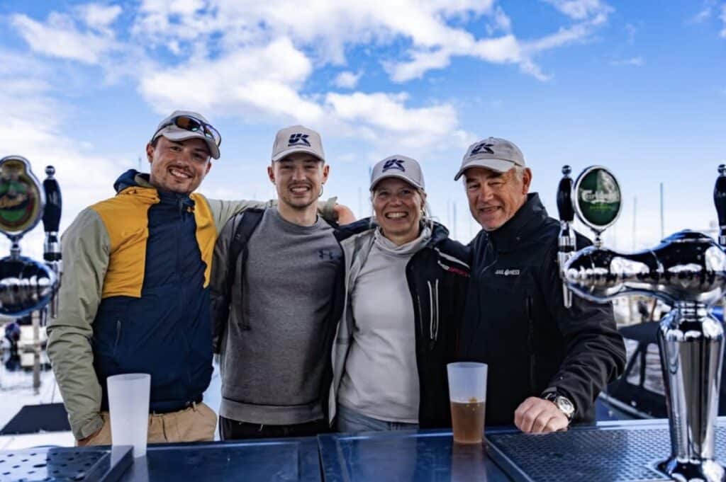Four sailors celebrate with drinks at a marina bar after the OK Dinghy Worlds