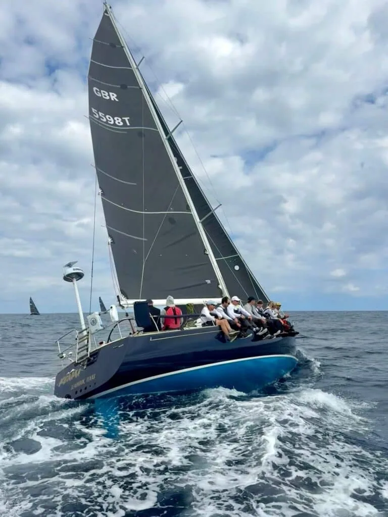 Kenai, GBR 5598T, sails with a full crew hiking hard on the rail