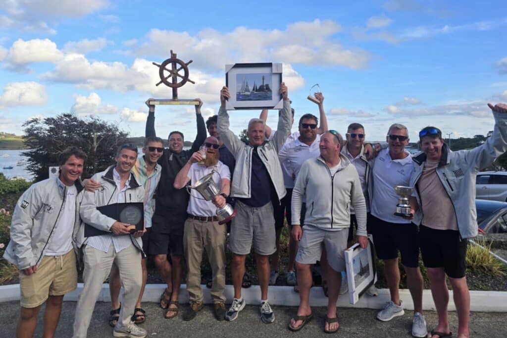 Artful DodJer's crew hoists their ship's-wheel trophy after Calves Week