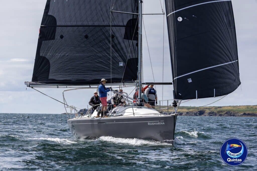Rosmarina sails under a black mainsail and asymmetric spinnaker