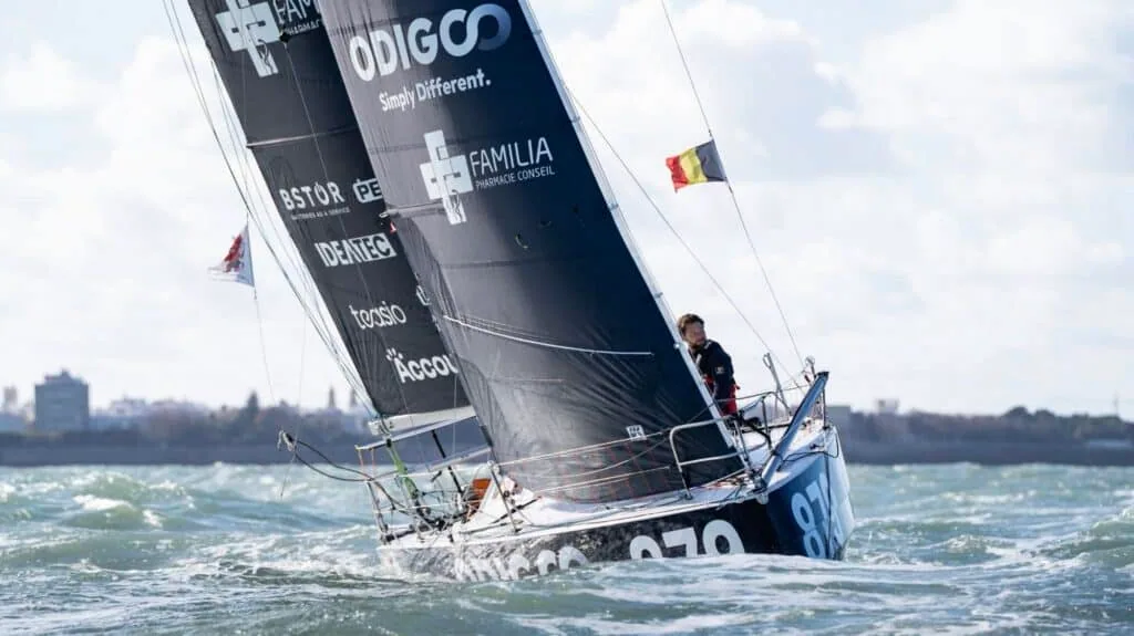 Quentin Debois braces at Odigo's helm, heeled hard through choppy seas