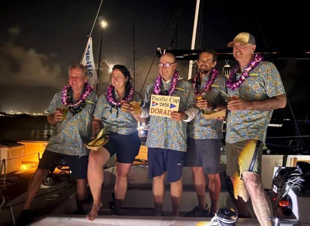 Dorado's five-person crew in matching aloha shirts and leis celebrating the Pacific Cup finish at night