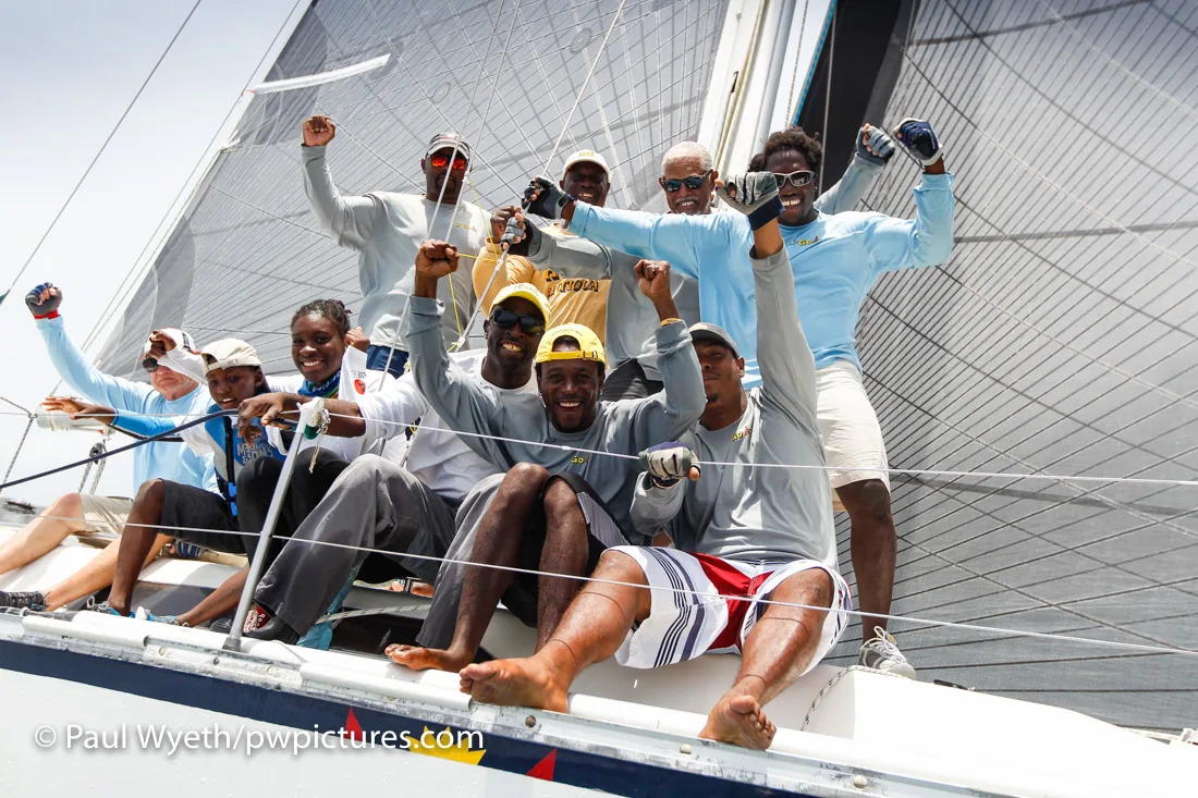 Sir Hugh Bailey and his crew cheering with raised fists on the foredeck after winning the Lord Nelson Trophy