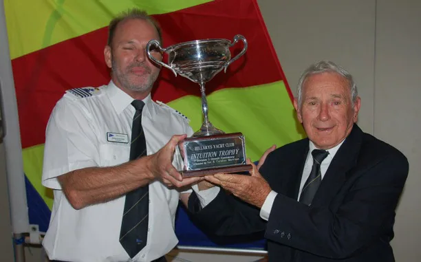 Kevin Stacey, right, holding the Intuition Trophy silver cup with a man in a white uniform shirt