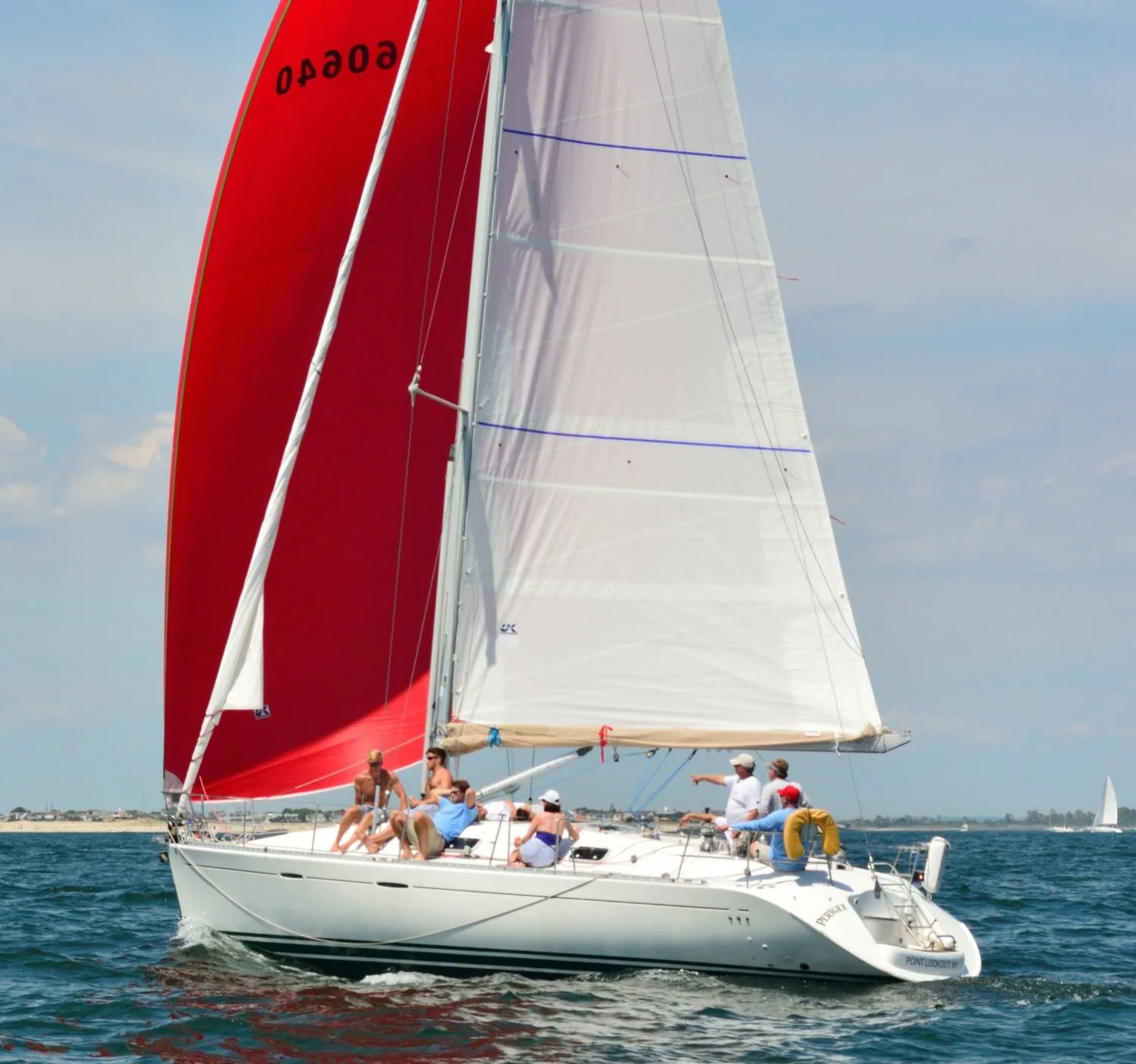 Beneteau First 42s7 PERIGEE reaching under a red asymmetric spinnaker, sail number 60640, with crew aboard