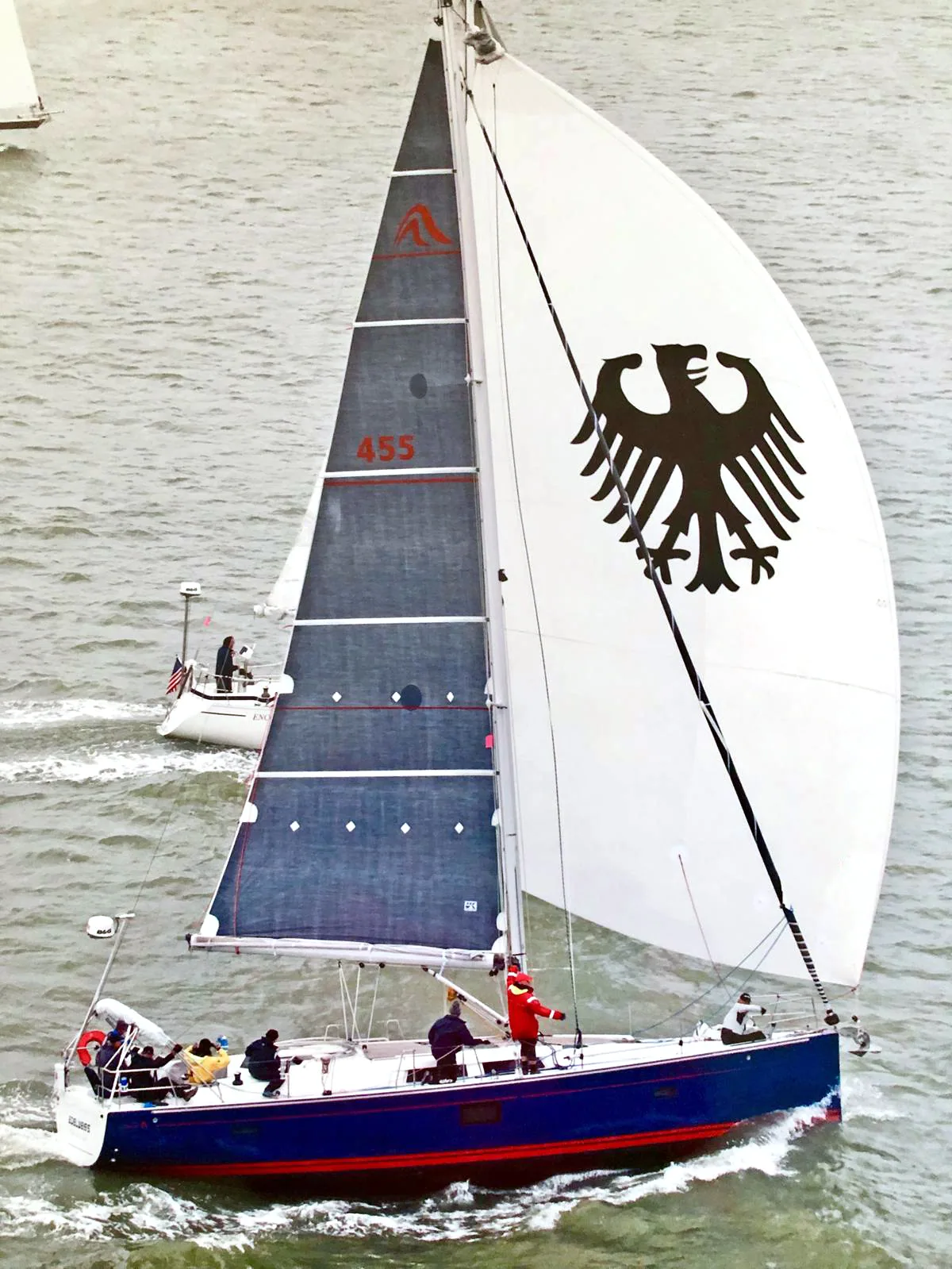 Hanse 455 EDELWEISS from above, blue hull, sail number 455 on a dark X-Drive® main, white spinnaker with a big black eagle