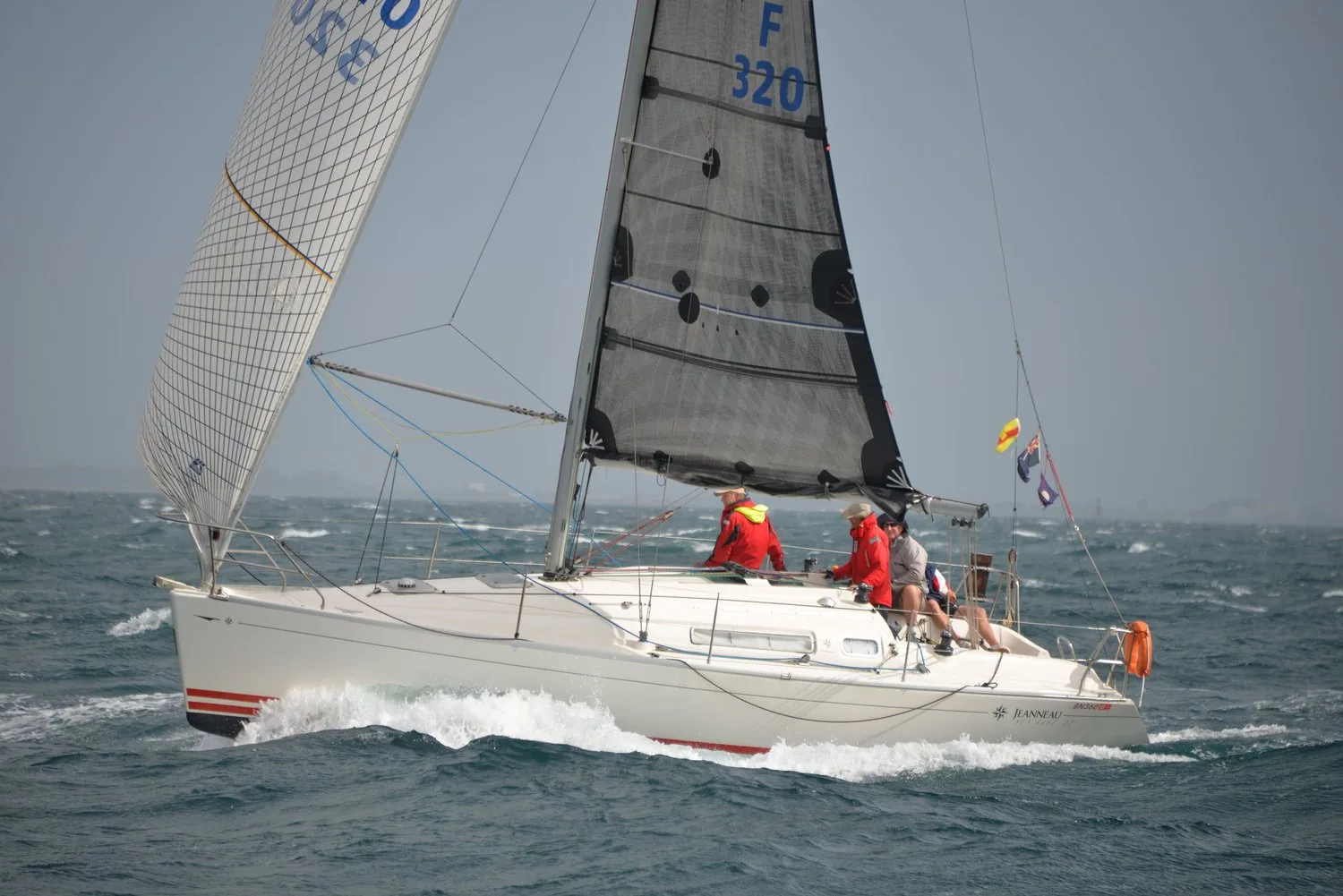 Sun Fast 32 WINDSWEPT, sail number F 320, beating upwind under a grey mainsail and white genoa, crew in red aft