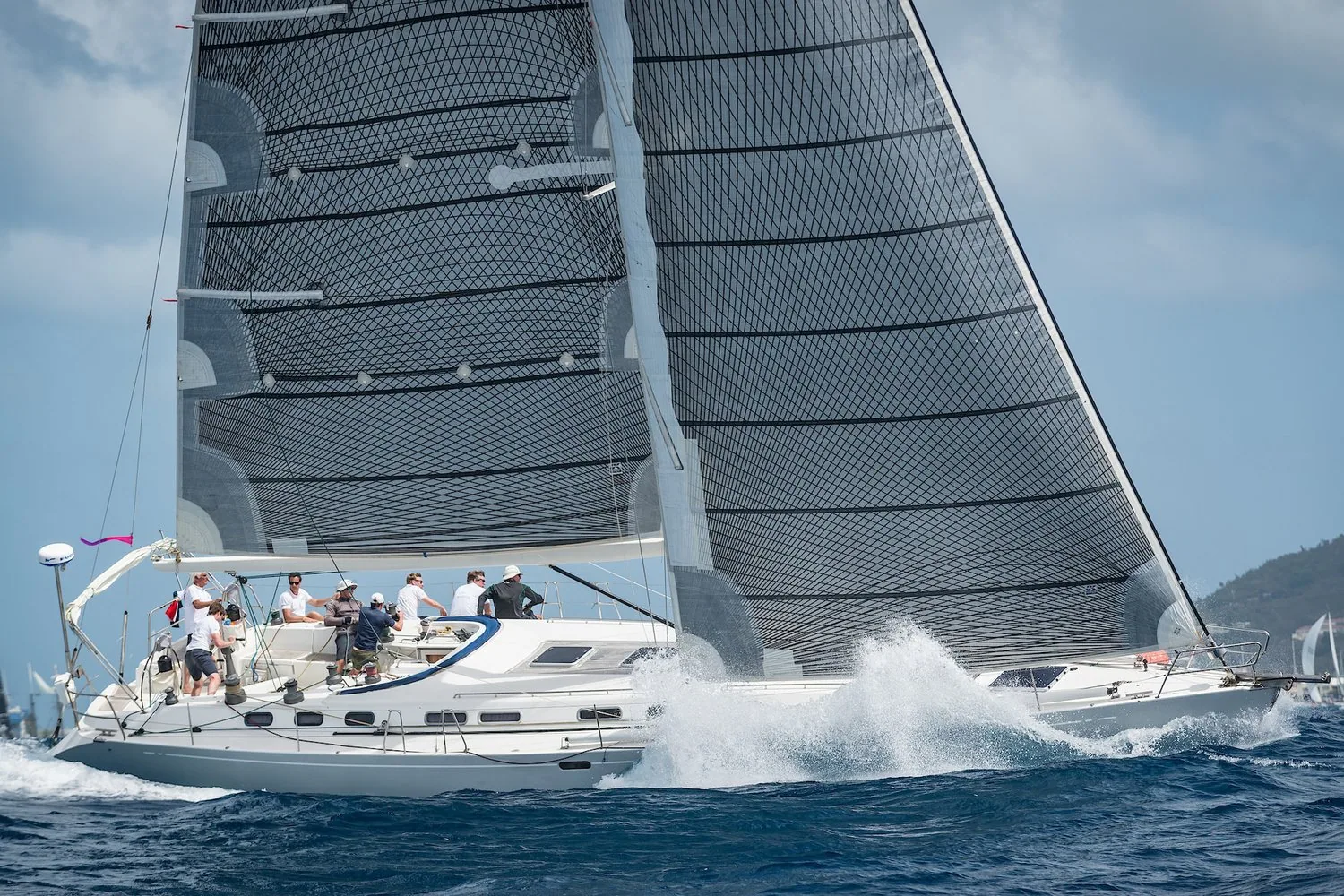 X-612 heeling upwind under grey mainsail and genoa with crew on the rail at the Heineken Regatta