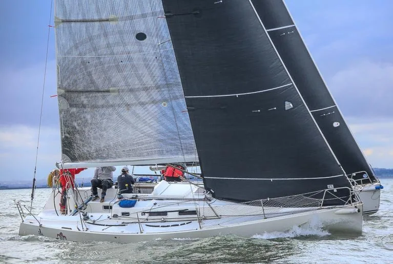 Two J/109s sailing upwind side by side under grey and black sails during two-boat testing
