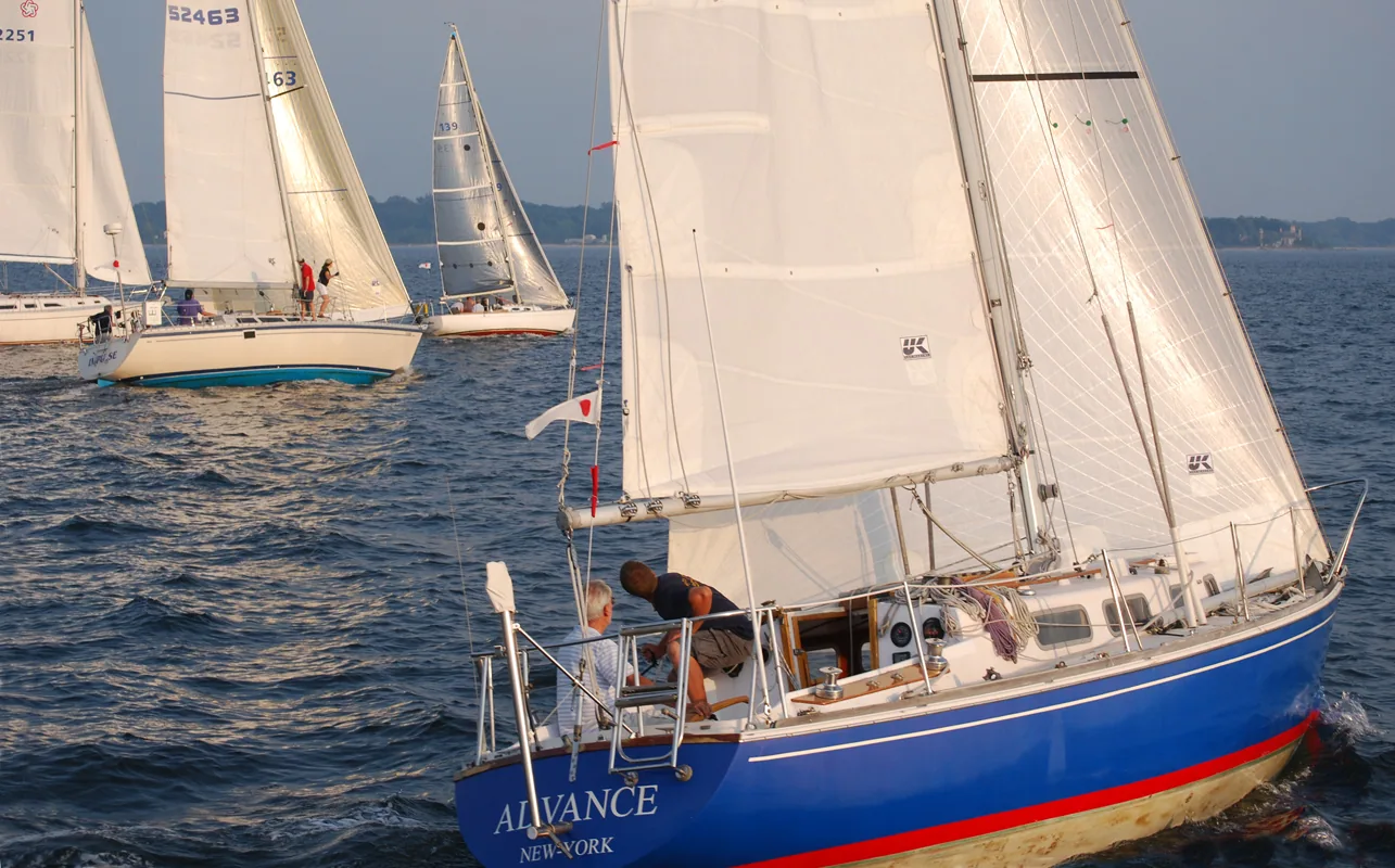 Blue-hulled sloop ADVANCE from New York sailing under white UK Sailmakers main and jib at an evening race