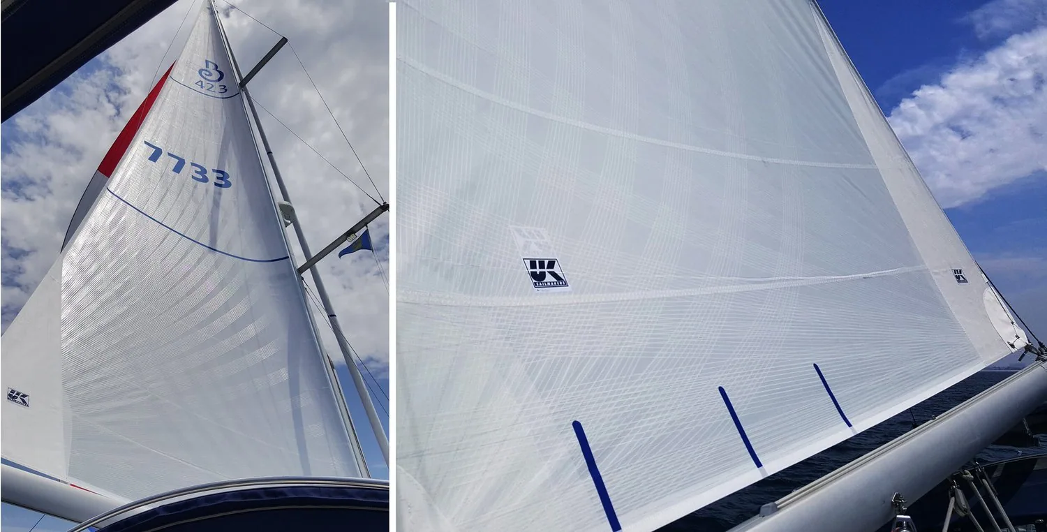 White roller-furling mainsail on a Beneteau 423, full sail beside the genoa and a close-up showing the UK Sailmakers logo
