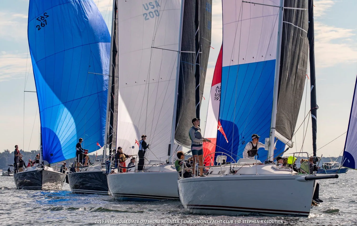 Tight pack of J/109s running under blue, white and red spinnakers at the 2019 Intercollegiate Offshore Regatta