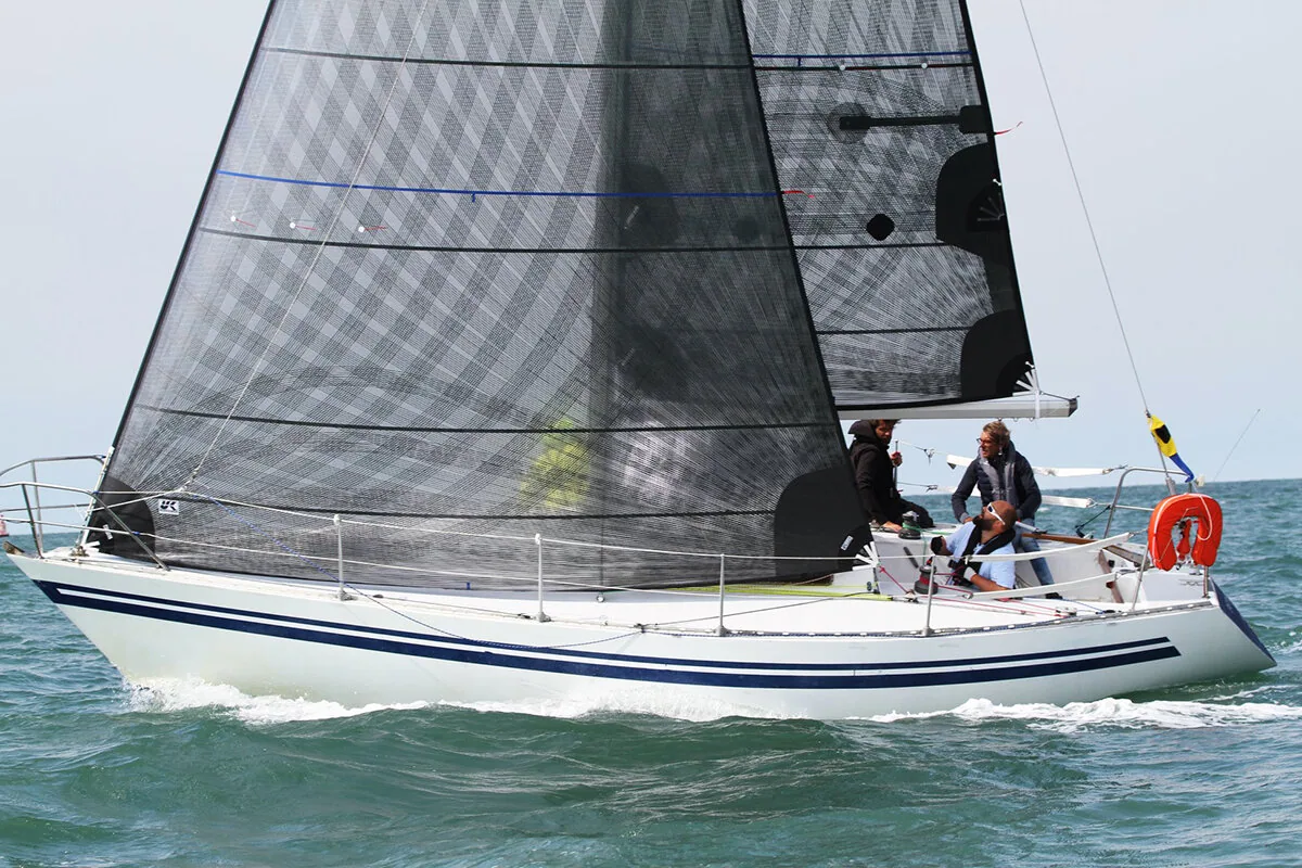 White Half Tonner sailing upwind under a black X-Drive® Carbon mainsail and jib, two crew in the cockpit