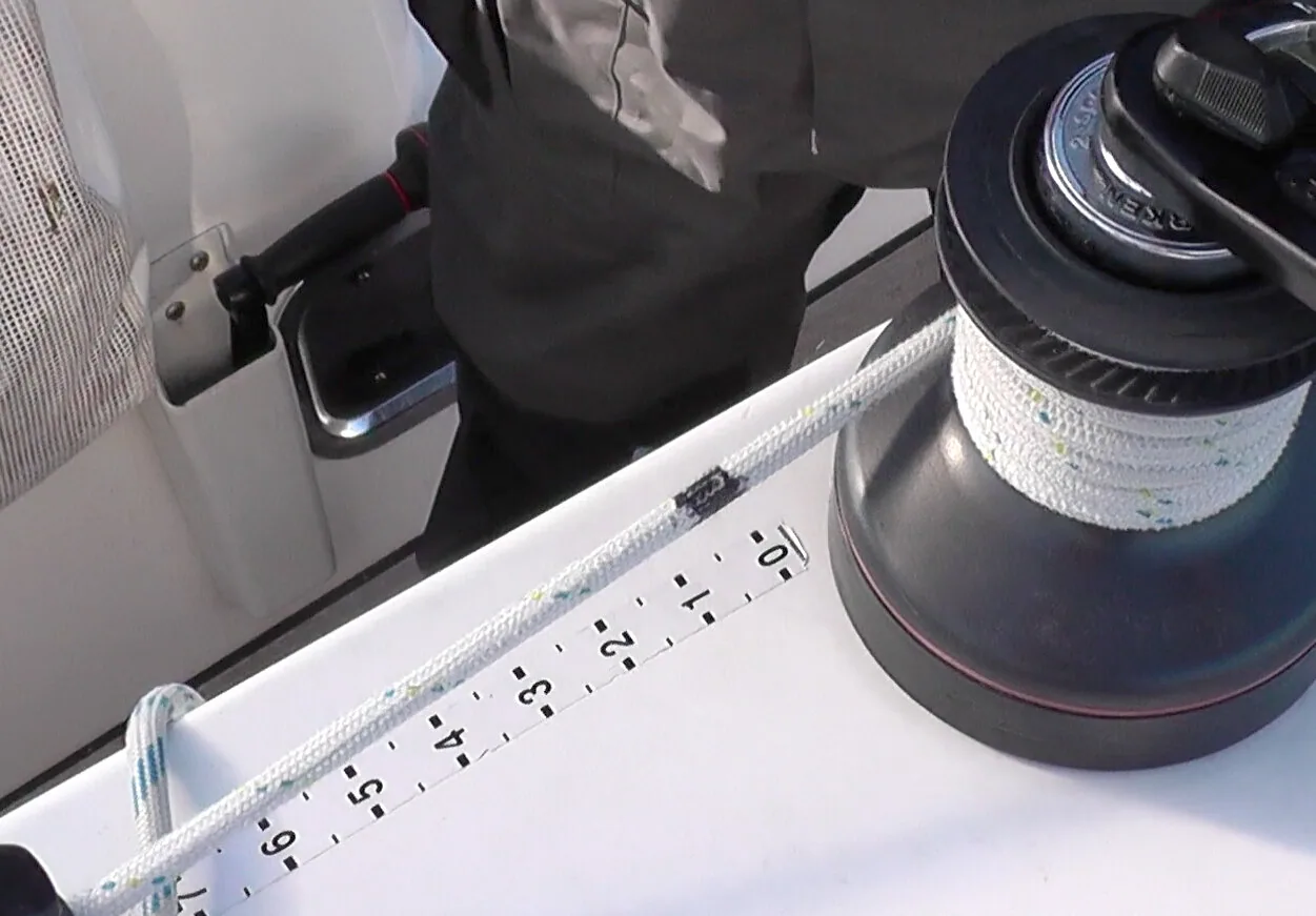 Halyard led to a winch drum past a numbered scale marked on deck, with a black mark on the line to repeat settings