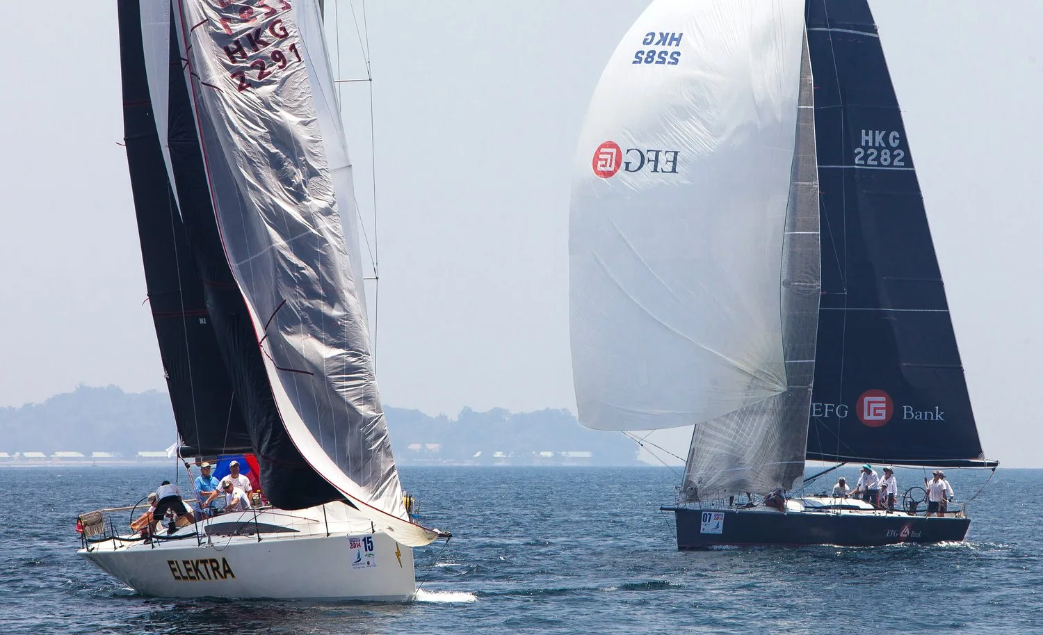 Racing yacht Elektra dousing her spinnaker at a mark while a dark-hulled HKG yacht runs behind under an EFG kite