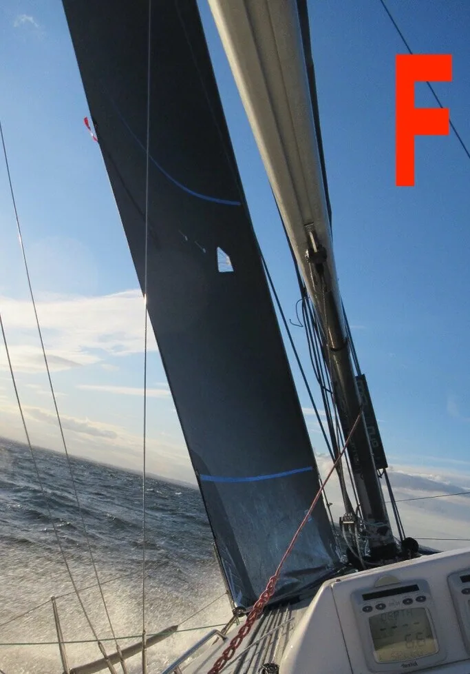 Photo F: black jib with a blue trim stripe seen from the cockpit, boom overhead and instruments below