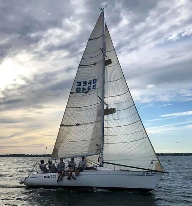 CELERITAS, sail number 3340, sailing under cream mainsail and genoa with five crew sitting on the rail