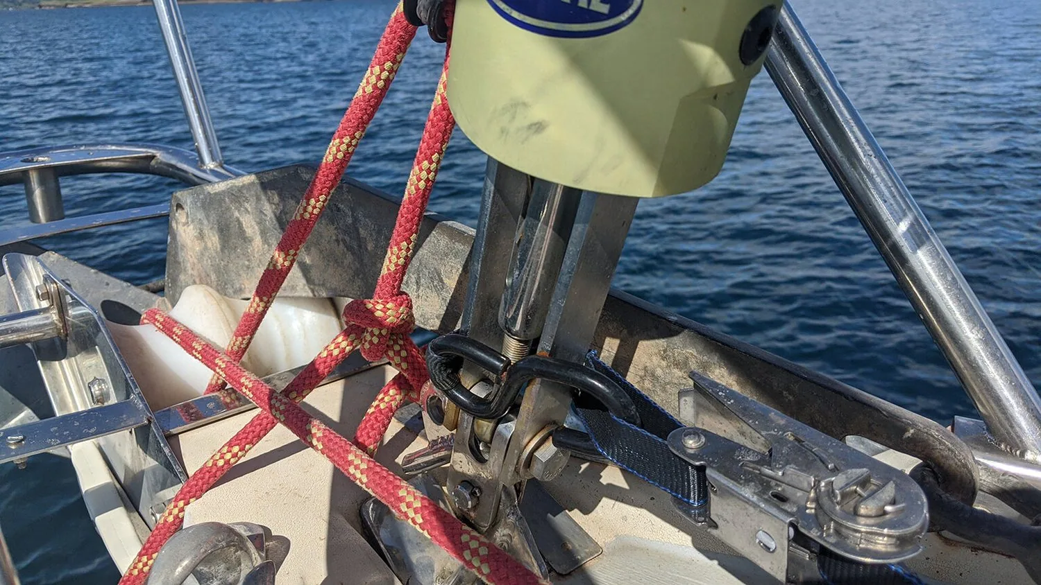 Jury-rigged headstay repair at PANDA's bow: red line lashing the furler drum to the stem fitting with a ratchet strap