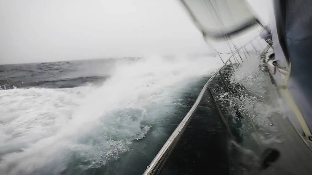 PANDA's lee rail buried in white water during a gale, grey sea and sky