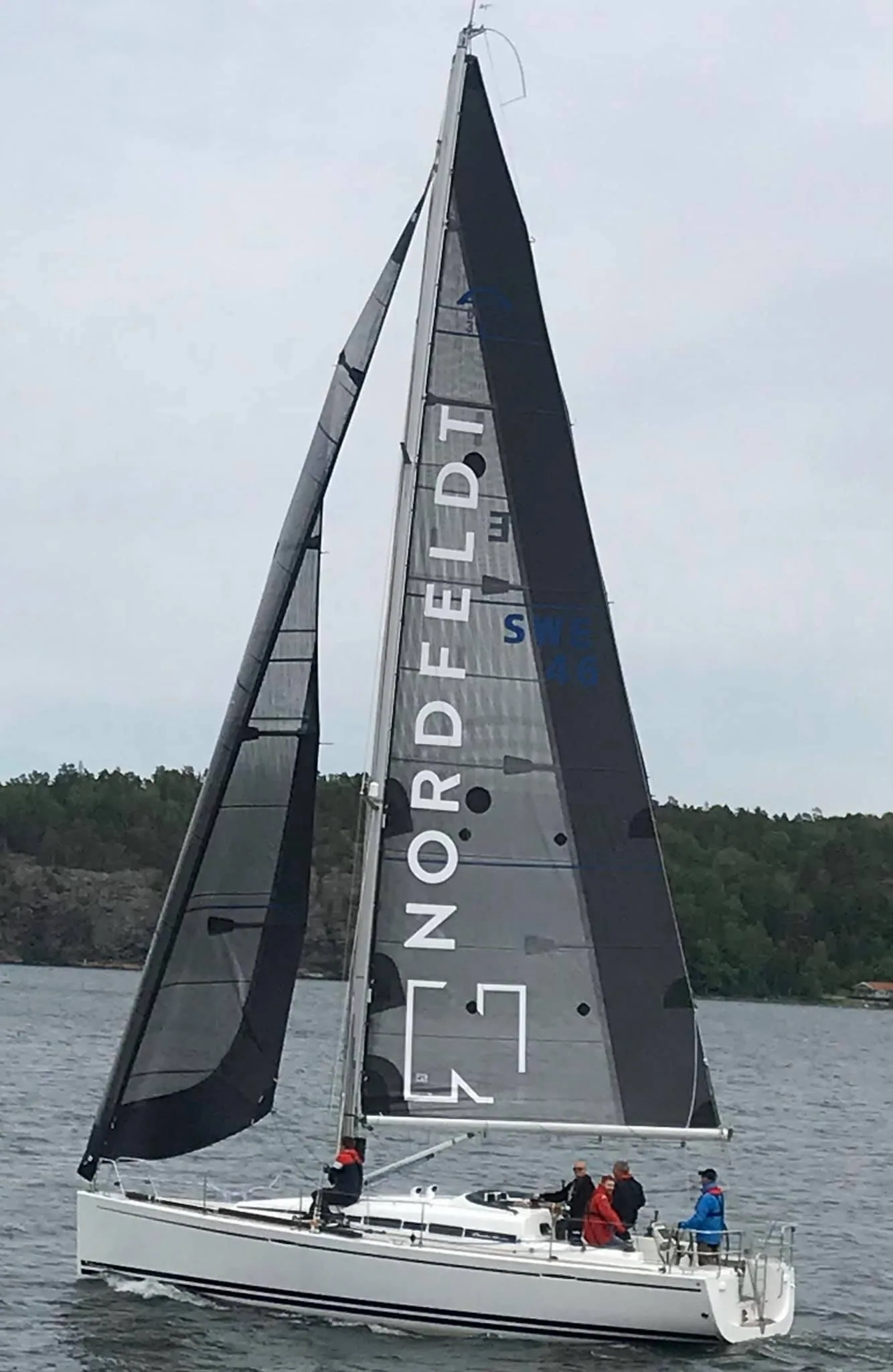 Arcona 380 UTOPIA under grey X-Drive® Carbon mainsail lettered NORDFELDT and matching jib, crew in the cockpit