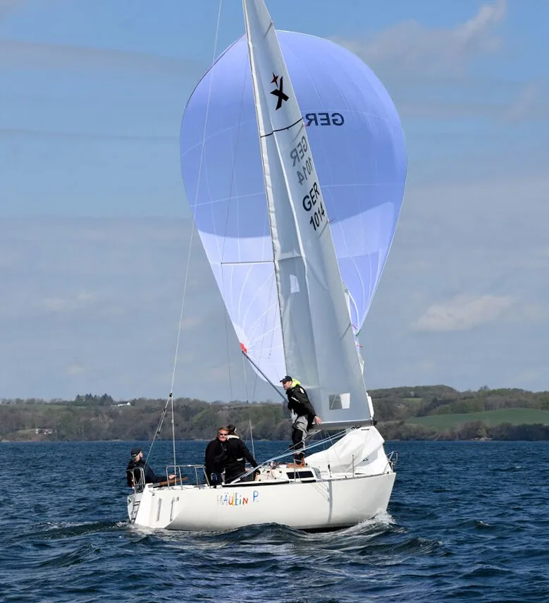 Albin Express Fraulin P, GER 104, running under a pale lilac spinnaker with three crew on deck